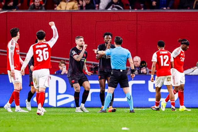 Referee Umut Meler is in discussion with Robert Andrich of Bayer 04 Leverkusen and Edmond Tapsoba of Bayer 04 Leverkusen after awarding a penalty to Arsenal FC Bayer 04 Leverkusen v Arsenal FC, UEFA Champions League 2025 26 Round of 16 First Leg, Bayer 04 Leverkusen v Arsenal FC, BayArena, March 11, 2026, Leverkusen, Germany.