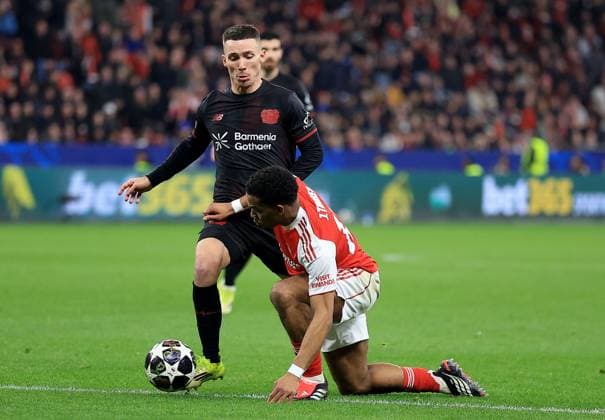 Alex Grimaldo of Bayer Leverkusen in action against Jurrien Timber of Arsenal Bayer 04 Leverkusen v Arsenal, UEFA Champions League, Round of 16, First Leg, Football, BayArena, Leverkusen, Germany - 11 Mar 2026Leverkusen BayArena Germany EDITORIAL USE ONLY No use with unauthorised audio, video, data, fixture lists, club league logos or live services. Online in-match use limited to 120 images, no video emulation. No use in betting, games or single club league player publications. Copyright: xGeorgexTewkesbury Shutterstockx 16746712bo