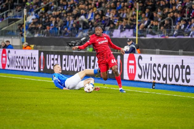 Belgien: Fussball Europa League 2025 - 2026, Achtelfinale - KRC Genk vs SC Freiburg - Cegeka Arena (Genk): Johan Manzambi (SC Freiburg, 44) Sponsoren, Werbung, Wirtschaft, Werbebande, Ausrüstung Swissquote Jobrad Copyright: xJOERANxSTEINSIEKx