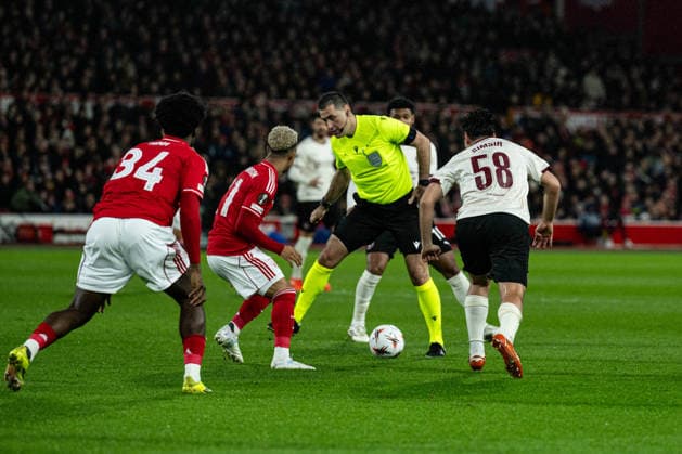 12th March 2026; The City Ground, Nottingham, England; UEFA Europa League Football, Nottingham Forest versus Midtjylland; Aral Simsir of FC Midtjylland nutmegs referee Rade Obrenovic  GodfreyxPitt Content restricted for UK based newspaper
