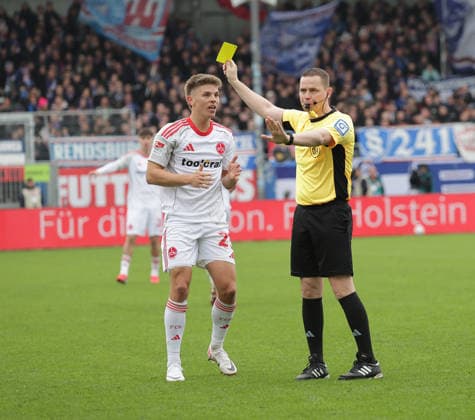 Fin Ole Becker (1.FC Nuernberg) bekommt von Schiedsrichter Dr.Robert Kampka die gelbe Karte Fussball, Herren, Saison 2025 2026, 2.BL, Holstein Stadion, Holstein Kiel gegen 1.FC Nuernberg, 2-3 DFL REGULATIONS PROHIBIT ANY USE OF PHOTOGRAPHS AS IMAGE SEQUENCES AND OR QUASI-VIDEO.