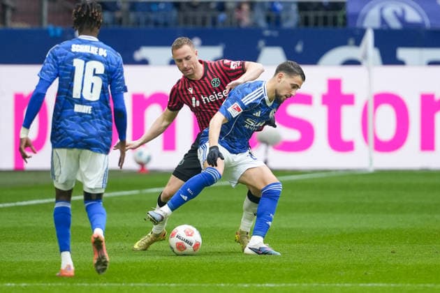 Fussball: 2. Bundesliga, 26. Spieltag, FC Schalke 04 - Hannover 96 am 15.03.2026 in Gelsenkirchen (VELTINS-Arena), Deutschland, Saison 2025 2026: DFB DFL REGULATIONS PROHIBIT ANY USE OF PHOTOGRAPHS as IMAGE SEQUENCES and or QUASI-VIDEO: Aouchiche, Adil (24,S04) im Zweikampf mit Neubauer, Maurice (33,H96). Gelsenkirchen VELTINS-Arena Deutschland