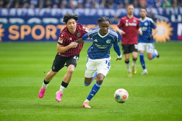 Fussball: 2. Bundesliga, 26. Spieltag, FC Schalke 04 - Hannover 96 am 15.03.2026 in Gelsenkirchen (VELTINS-Arena), Deutschland, Saison 2025 2026: DFB DFL REGULATIONS PROHIBIT ANY USE OF PHOTOGRAPHS as IMAGE SEQUENCES and or QUASI-VIDEO: Ndiaye, Moussa (16,S04) im Zweikampf mit Yokota, Daisuke (18,H96). Gelsenkirchen VELTINS-Arena Deutschland