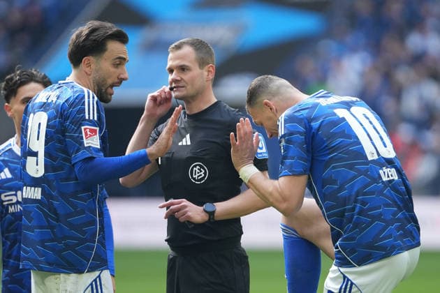 Fussball: 2. Bundesliga, 26. Spieltag, FC Schalke 04 - Hannover 96 am 15.03.2026 in Gelsenkirchen (VELTINS-Arena), Deutschland, Saison 2025 2026: DFB DFL REGULATIONS PROHIBIT ANY USE OF PHOTOGRAPHS as IMAGE SEQUENCES and or QUASI-VIDEO: Karaman, Kenan (19, S04) diskutiert mit Dr. Robin Braun (Schiedsrichter) über die Rote Karte von Dzeko, Edin (10, S04). Gelsenkirchen VELTINS-Arena Deutschland
