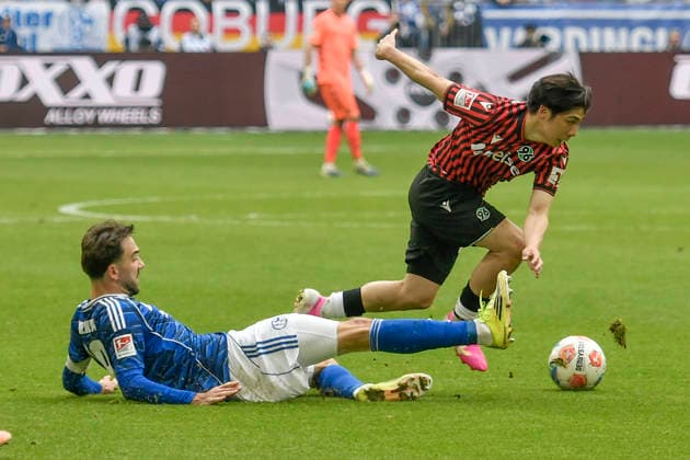 v. li. im Kampf um den Ball Kenan Karaman (Schalke 19) Daisuke Yokota (Hannover 18) 15.03.2026 ¢ Fussball ¢ FC Schalke 04 vs Hannover 96, Veltins-Arena, Gelsenkirchen, DFB DFL REGULATIONS PROHIBIT ANY USE OF PHOTOGRAPHS AS IMAGE SEQUENCES AND OR QUASI-VIDEO