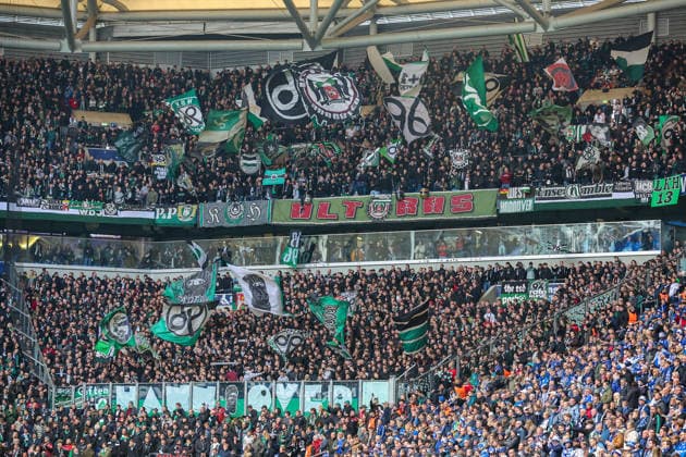 2. Bundesliga - FC Schalke 04 - Hannover 96 am 15.03.2026 in der Veltins-Arena auf Schalke Die Hannover 96 Fans schwenken im Gästeblock Fahnen
