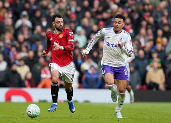Manchester, England, 15th March 2026. Bruno Fernandes of Manchester United, ManU tussles with Morgan Rogers of Aston Villa during the Manchester United vs Aston Villa Premier League match at Old Trafford, Manchester. Picture credit should read: Andrew Yates Sportimage EDITORIAL USE ONLY. No use with unauthorised audio, video, data, fixture lists, club league logos or live services. Online in-match use limited to 120 images, no video emulation. No use in betting, games or single club league player publications. SPI_080_AY_Man_Utd_Villa SPI-4605-0081