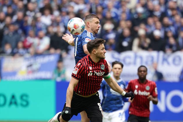 Gelsenkirchen, Germany, 15.03.26, Edin Dzeko (FC Schalke 04) und Enzo Leopold (Hannover 96) im Zweikampf während des Spiels der 2. Bundesliga zwischen FC Schalke 04 - Hannover 96 in der Veltins Arena in Gelsenkirchen. (Photo by Joachim Bywaletz) DFB DFL REGULATIONS PROHIBIT ANY USE OF PHOTOGRAPHS AS IMAGE SEQUENCES AND OR QUASI-VIDEO.