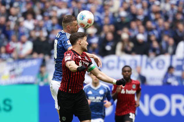Gelsenkirchen, Germany, 15.03.26, Edin Dzeko (FC Schalke 04) und Enzo Leopold (Hannover 96) im Zweikampf während des Spiels der 2. Bundesliga zwischen FC Schalke 04 - Hannover 96 in der Veltins Arena in Gelsenkirchen. (Photo by Joachim Bywaletz) DFB DFL REGULATIONS PROHIBIT ANY USE OF PHOTOGRAPHS AS IMAGE SEQUENCES AND OR QUASI-VIDEO.