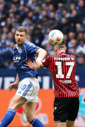 Gelsenkirchen, Germany, 15.03.26, Edin Dzeko (FC Schalke 04) und Bastian Allgeier (Hannover 96) im Zweikampf während des Spiels der 2. Bundesliga zwischen FC Schalke 04 - Hannover 96 in der Veltins Arena in Gelsenkirchen. (Photo by Joachim Bywaletz) DFB DFL REGULATIONS PROHIBIT ANY USE OF PHOTOGRAPHS AS IMAGE SEQUENCES AND OR QUASI-VIDEO.