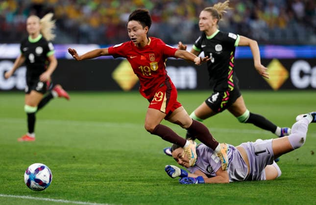 (260317) -- PERTH, March 17, 2026 -- Zhang Linyan (L, top) of China is tackled by Mackenzie Arnold (bottom), goalkeeper of Australia, during the semifinal of Women s Asian Cup between China and Australia at Perth Stadium in Perth, Australia, March 17, 2026. ) (SP)AUSTRALIA-PERTH-FOOTBALL-WOMEN S ASIAN CUP-SEMIFINAL-CHN VS AUS MaxPing 