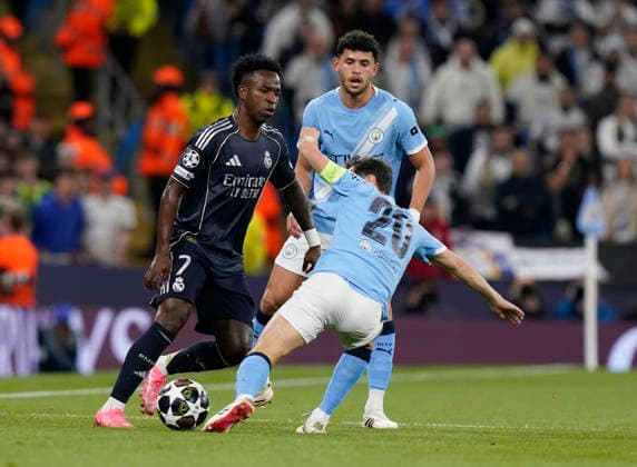 Manchester, England, 17th March 2026. Vinicius Junior of Real Madrid tussles with Bernardo Silva of Manchester City during the Manchester City vs Real Madrid UEFA Champions League round of 16 match at the Etihad Stadium, Manchester. Picture credit should read: Andrew Yates Sportimage EDITORIAL USE ONLY. No use with unauthorised audio, video, data, fixture lists, club league logos or live services. Online in-match use limited to 120 images, no video emulation. No use in betting, games or single club league player publications. SPI_022_AY_ManCity_Madrid SPI-4612-0035