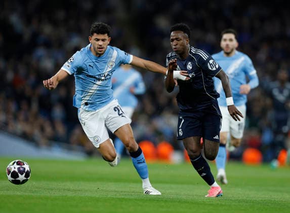 Manchester, England, 17th March 2026. Matheus Nunes of Manchester City tussles with Vinicius Junior of Real Madrid during the Manchester City vs Real Madrid UEFA Champions League round of 16 match at the Etihad Stadium, Manchester. Picture credit should read: Cody Froggatt Sportimage EDITORIAL USE ONLY. No use with unauthorised audio, video, data, fixture lists, club league logos or live services. Online in-match use limited to 120 images, no video emulation. No use in betting, games or single club league player publications. SPI_016_CF_ManCity_Madrid SPI-4612-0038