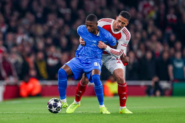 LONDON, ENGLAND - MARCH 17: Christian Kofane of Bayer 04 Leverkusen and William Saliba of Arsenal battle for the ball during the UEFA Champions League 2025 26 Round of 16 Second Leg match between Arsenal FC and Bayer 04 Leverkusen at Arsenal Stadium on March 17, 2026 in London, England.  Copyright: xRenexNijhuis MBxMediax
