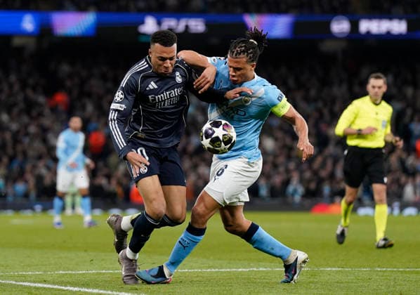 Manchester, England, 17th March 2026. Kylian Mbappe of Real Madrid tackled by Nathan Ake of Manchester City during the Manchester City vs Real Madrid UEFA Champions League round of 16 match at the Etihad Stadium, Manchester. Picture credit should read: Andrew Yates Sportimage EDITORIAL USE ONLY. No use with unauthorised audio, video, data, fixture lists, club league logos or live services. Online in-match use limited to 120 images, no video emulation. No use in betting, games or single club league player publications. SPI_058_AY_ManCity_Madrid SPI-4612-0105