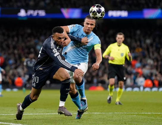 Manchester, England, 17th March 2026. Kylian Mbappe of Real Madrid tackled by Nathan Ake of Manchester City during the Manchester City vs Real Madrid UEFA Champions League round of 16 match at the Etihad Stadium, Manchester. Picture credit should read: Andrew Yates Sportimage EDITORIAL USE ONLY. No use with unauthorised audio, video, data, fixture lists, club league logos or live services. Online in-match use limited to 120 images, no video emulation. No use in betting, games or single club league player publications. SPI_057_AY_ManCity_Madrid SPI-4612-0106