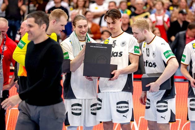 19.03.2026, Handball, Länderspiel Herren, Deutschland - Ägypten, Westfalenhalle Dortmund: Eindrücke rund um die Ehrung der Vize Europameister 2026 nach dem Spiel. Die Spieler werden für den zweiten Platz bei der Europameisterschaft geehrt. David Späth (Germany 01) Juri Knorr (Germany 15) Miro Schluroff (Germany 05) Matthes Langhoff (Germany 13) schauen neugierig in die Geschenkbox von Ingo Meckes Nordrhein-Westfalen Deutschland