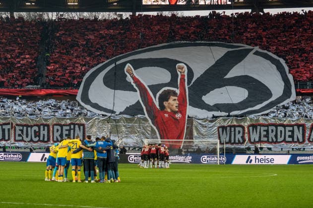 Deutschland: Fussball 2. Bundesliga, 27. Spieltag 2025 2026, Hannover 96 - Eintracht Braunschweig am 20.03. in Hannover (Heinz von Heiden Arena): Fans, Spruchband, Fahne, Transparent, Mannschaftskreise vor dem Spiel
