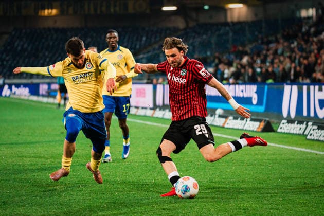 2. Bundesliga: Hannover 96 vs. Eintracht Braunschweig, 20.03.2026 Kolja Nuno Oudenne (Hannover 96, 29) flankt den Ball, Mehmet Can Aydin (Eintracht Braunschweig, 8) kommt zu spät; Fußball, 2. Bundesliga, 27. Spieltag: Hannover 96 vs. Eintracht Braunschweig am 20.03.2026 in der Heinz von Heiden Arena, Hannover DFL REGULATIONS PROHIBIT ANY USE OF PHOTOGRAPHS AS IMAGE SEQUENCES AND OR QUASI-VIDEO.