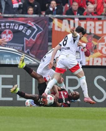 21.03.2026 - Fussball - Saison 2025 2026 - 2. Fussball - Bundesliga - 27. Spieltag: 1. FC Nürnberg FCN ( Club ) - 1. FC Kaiserslautern FCK ( Rote Roten Teufel ) - Sportfoto Zink DaMa - xdaxmax - DFL regulations prohibit any use of photographs as image sequences and or quasi-video - only for editorial use - Mika Haas (22, 1. FC Kaiserslautern FCK ) Semih Sahin (8, 1. FC Kaiserslautern FCK ) bringen Mohamed Ali Zoma (23, 1. FC Nürnberg FCN ) im Strafraum zum Elfmeter zu Fall Foul