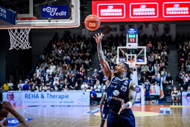 easycredit BBL Basketball Bundesliga 2025 2026 25. Spieltag 21.03.2026 Science City Jena vs SYNTAINICS MBC Charles Callison (MBC) mit dem freien Korbleger. 60 Jahre BBL Logo auf dem Ball Sparkassen Arena