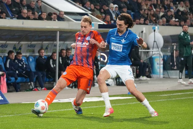 Deutschland: Fussball 2. Bundesliga 2025 26, 27. Spieltag - SV Darmstadt 98 vs FC Schalke 04 - Merck-Stadion am Böllenfalltor: Timo Becker (Schalke 04, 5) gegen Fraser Hornby (SV Darmstadt, 9)