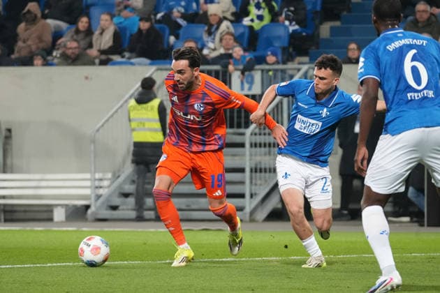 Deutschland: Fussball 2. Bundesliga 2025 26, 27. Spieltag - SV Darmstadt 98 vs FC Schalke 04 - Merck-Stadion am Böllenfalltor: Kenan Karaman (Schalke 04, 19) gegen Matondo-Merveille Papela (SV Darmstadt, 21)