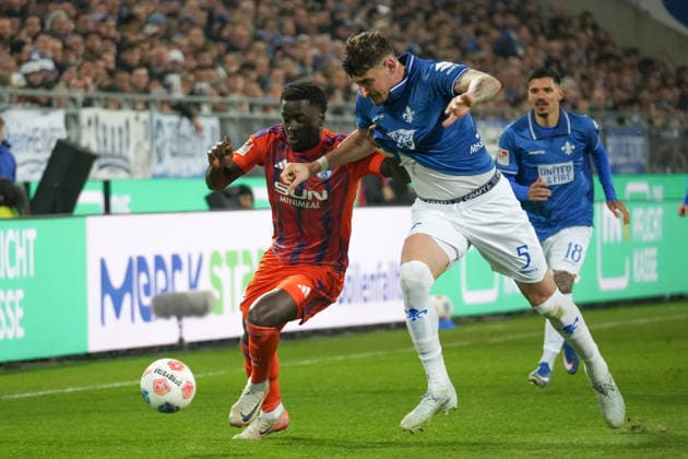 Deutschland: Fussball 2. Bundesliga 2025 26, 27. Spieltag - SV Darmstadt 98 vs FC Schalke 04 - Merck-Stadion am Böllenfalltor: Christian Gomis (Schalke 04, 7) gegen Matej Maglica (SV Darmstadt, 5)