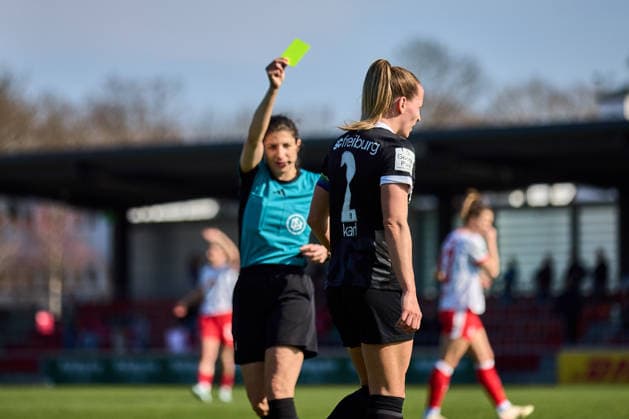 22.03.2026, GER, Frauenfußball, BL, 2025 2026, RB Leipzig - SC Freiburg Gelbe Karte für Lisa Karl (2, SC Freiburg), im Hintergrund Schiedsrichter Dr. Riem Hussein Leipzig Trainingszentrum der Roten Bulle Sachsen Deutschland