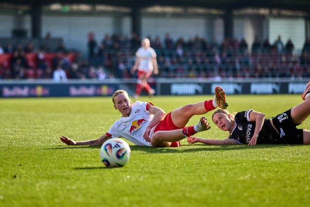 22.03.2026, GER, Frauenfußball, BL, 2025 2026, RB Leipzig - SC Freiburg Marlene Müller (27, RB Leipzig, li.), Nia Szenk (19, SC Freiburg), beide am Boden, nach Zweikampf um Ball Leipzig Trainingszentrum der Roten Bulle Sachsen Deutschland