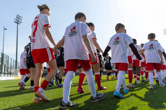 GER, Leipzig, Fußball, Google Pixel Frauen Bundesliga, 21. Spieltag, RB Leipzig vs. SC Freiburg im Bild v.l.: Marlene Mueller (RB Leipzig 27), mit Einlaufkind an der Hand laeuft mit den Mannschaften auf das Feld ein, Kinder tragen Bullis Bande T-Shirts, Kinderclub RB Leipzig 22.03.2025, RB Leipzig Training Akademie Cottaweg Leipzig DFB REGULATIONS PROHIBIT ANY USE OF PHOTOGRAPHS AS IMAGE SEQUENCES AND OR QUASI-VIDEO, Copyright: HMBxMedia PaulxFritz