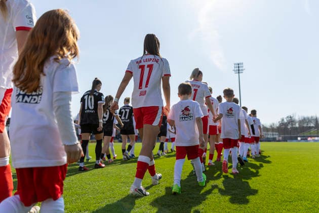 GER, Leipzig, Fußball, Google Pixel Frauen Bundesliga, 21. Spieltag, RB Leipzig vs. SC Freiburg im Bild v.l.: Lisa Baum (RB Leipzig 11), laueft mit den Mannschaften auf das Feld, mit Einlaufkind an der Hand, EInlaufkind traegt Bullis Bande T-Shirt ( RB Leipzig Kinderclub ) 22.03.2025, RB Leipzig Training Akademie Cottaweg Leipzig DFB REGULATIONS PROHIBIT ANY USE OF PHOTOGRAPHS AS IMAGE SEQUENCES AND OR QUASI-VIDEO, Copyright: HMBxMedia PaulxFritz