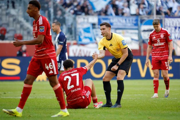 Düsseldorf , Deutschland, 2. Fussball Bundesliga Saison 2025 26 27. Spieltag Fortuna Düsseldorf : Hertha BSC Berlin 2:5 am 22. 03. 2026 in der Merkur -Spiel -Arena in Düsseldorf Schiedsrichter Eric WEISBACH hilft Jordi Leander PAULINA (F 95) beim Aufstehen