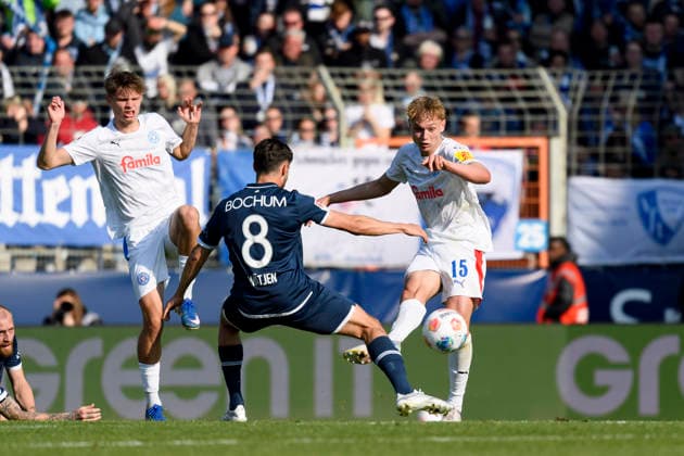 Frederik Roslyng (Holstein Kiel), Kjell Waetjen (VfL Bochum) und Kasper Davidsen (Holstein Kiel) im Kampf um den Ball waehrend des spiels der 2. Bundesliga zwischen VfL Bochum und Holstein Kiel, Vonovia Ruhrstadion am 22. March 2026 in Bochum, Deutschland. (Foto von Max Maiwald DeFodi Images) +++ Frederik Roslyng (Holstein Kiel), Kjell Waetjen (VfL Bochum) und Kasper Davidsen (Holstein Kiel) battle for the ball during the 2. Bundesliga match between VfL Bochum and Holstein Kiel at Vonovia Ruhrstadion on March 22, 2026 in Bochum, Germany. (Photo by Max Maiwald DeFodi Images) (Photo by Max Maiwald DeFodi Images) -