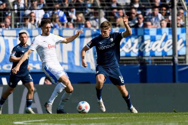Jonas Meffert (Holstein Kiel) und Callum Marshall (VfL Bochum) im Kampf um den Ball waehrend des spiels der 2. Bundesliga zwischen VfL Bochum und Holstein Kiel, Vonovia Ruhrstadion am 22. March 2026 in Bochum, Deutschland. (Foto von Max Maiwald DeFodi Images) +++ Jonas Meffert (Holstein Kiel) und Callum Marshall (VfL Bochum) battle for the ball during the 2. Bundesliga match between VfL Bochum and Holstein Kiel at Vonovia Ruhrstadion on March 22, 2026 in Bochum, Germany. (Photo by Max Maiwald DeFodi Images) (Photo by Max Maiwald DeFodi Images) -