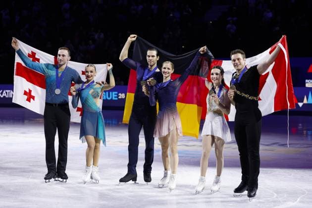 Figure skating, Eiskunstlauf World championships in Prague Minerva Fabienne Hase (C,R) and Nikita Volodin (C,L) of Germany celebrate after winning the pairs gold at the world figure skating championships in Prague on March 26, 2026, alongside silver medalists Anastasiia Metelkina (2nd from L) and Luka Berulava (far L) of Georgia, and bronze medalists Lia Pereira (2nd from R) and Trennt Michaud of Canada.  A14AA0005420360P