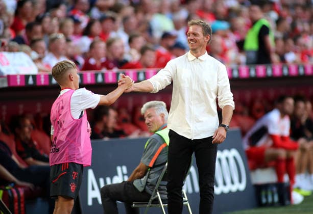 Fussball, Herren, Bundesliga, Saison 2022 2023, FC Bayern München - VFL Wolfsburg, Allianz Arena Hier im Bild der Balljunge Lennart Karl (FC Bayern München) im jungen Alter mit dem damaligen Trainer Julian Nagelsmann (FC Bayern München) an der Seitenlinie unter dem Spiel, abklatschen, hand geben