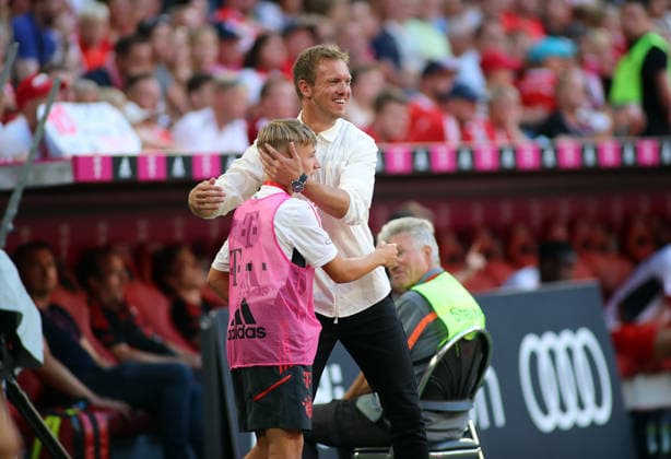 Fussball, Herren, Bundesliga, Saison 2022 2023, FC Bayern München - VFL Wolfsburg, Allianz Arena Hier im Bild der Balljunge Lennart Karl (FC Bayern München) im jungen Alter mit dem damaligen Trainer Julian Nagelsmann (FC Bayern München) an der Seitenlinie unter dem Spiel, umarmen