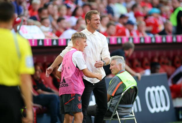 Fussball, Herren, Bundesliga, Saison 2022 2023, FC Bayern München - VFL Wolfsburg, Allianz Arena Hier im Bild der Balljunge Lennart Karl (FC Bayern München) im jungen Alter mit dem damaligen Trainer Julian Nagelsmann (FC Bayern München) an der Seitenlinie unter dem Spiel