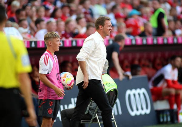 Fussball, Herren, Bundesliga, Saison 2022 2023, FC Bayern München - VFL Wolfsburg, Allianz Arena Hier im Bild der Balljunge Lennart Karl (FC Bayern München) im jungen Alter mit dem damaligen Trainer Julian Nagelsmann (FC Bayern München) an der Seitenlinie unter dem Spiel