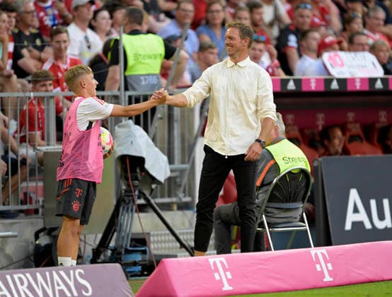 14.08.2022, Fussball 1. Bundesliga 2022 2023, 02.Spieltag, FC Bayern München - VfL Wolfsburg, in der Allianz-Arena München. Während einer VAR-Pause macht Trainer Julian Nagelsmann (re, FC Bayern München) spässe mit einem Balljungen, der Balljunge ist der jetzige Nachwuchsstar Lennart Karl (FC Bayern München)