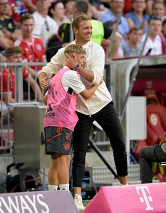 14.08.2022, Fussball 1. Bundesliga 2022 2023, 02.Spieltag, FC Bayern München - VfL Wolfsburg, in der Allianz-Arena München. Während einer VAR-Pause umarmt Trainer Julian Nagelsmann (re, FC Bayern München) einen Balljungen, der Balljunge ist der jetzige Nachwuchsstar Lennart Karl (FC Bayern München)