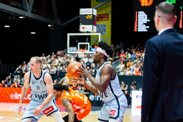 28.03.2026, xomx, Basketball easyCredit BBL Bundesliga, NINERS Chemnitz - EWE Baskets Oldenburg v.l. Seth Hinrichs (EWE Baskets Oldenburg), Nike Sibande (Niners Chemnitz) und Brian Fobbs (EWE Baskets Oldenburg) vor den Augen von Lazar Spasic (EWE Baskets Oldenburg Headcoach Trainer) im Kampf um den Ball. Chemnitz