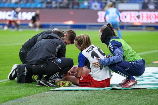 v.li.: Victoria Schulz (Hamburger SV, HSV, 19) sitzt verletzt am Boden, Verletzung, Schmerzen, schmerzverzerrtes Gesicht, Emilia Hirche (Hamburger SV, HSV, 20) kümmert sich um sie, DIE DFB-RICHTLINIEN UNTERSAGEN JEGLICHE NUTZUNG VON FOTOS ALS SEQUENZBILDER UND ODER VIDEOÄHNLICHE FOTOSTRECKEN. DFB REGULATIONS PROHIBIT ANY USE OF PHOTOGRAPHS AS IMAGE SEQUENCES AND OR QUASI-VIDEO., 30.03.2026, Hamburg (Deutschland), Fussball, Google Pixel Frauen-Bundesliga, Hamburger SV - Bayer 04 Leverkusen