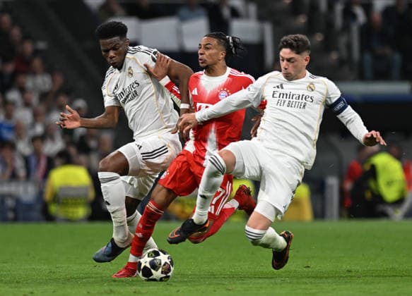 (260408) -- MADRID, April 8, 2026 -- Michael Olise (C) of Bayern Munich vies with Federico Valverde (R) and Aurelien Tchouameni of Real Madrid during the 2025 2026 UEFA Champions League quarterfinal first leg football match between Real Madrid and Bayern Munich in Madrid, Spain, April 7, 2026. ) (SP)SPAIN-MADRID-FOOTBALL-UEFA CHAMPIONS LEAGUE-REAL MADRID VS BAYERN MUNICH ChengxMin 