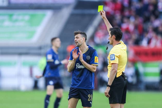 Fußball 2. Bundesliga 29. Spieltag Fortuna Düsseldorf - Holstein Kiel am 10.04.2026 in der Merkur Spiel-Arena in Düsseldorf Schiedsrichter Matthias Jöllenbeck ( Freiburg ), rechts - zeigt Jonas Meffert ( Kiel ), links - die gelbe Karte DFL regulations prohibit any use of photographs as image sequences and or quasi-video. *** Soccer 2 Bundesliga 29 Matchday Fortuna Düsseldorf Holstein Kiel on 10 04 2026 at Merkur Spiel Arena in Düsseldorf Referee Matthias Jöllenbeck Freiburg , right shows Jonas Meffert Kiel , left the yellow card DFL regulations prohibit any use of photographs as image sequences and or quasi video xJRx