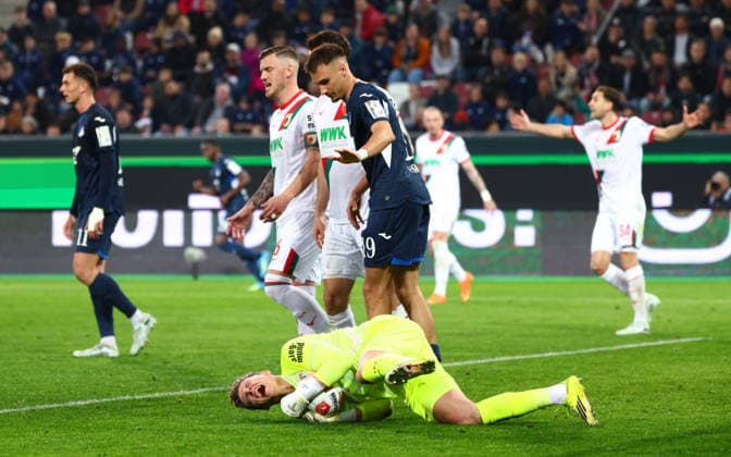 Finn Dahmen (1, FC Augsburg) liegt am Boden im Hintergrund Tim Lemperle (19, TSG 1899 Hoffenheim) beim Spiel zwischen FC Augsburg v TSG 1899 Hoffenheim, Fußball, Herren, Bundesliga, 2025 2026, 29.Spieltag am 10.04.2026 in Augsburg, WWK ARENA. DFL and DFB regulations prohibit any use of photographs as image sequences and or quasi-video. Bayern Deutschland *** Finn Dahmen 1, FC Augsburg lies on the ground in the background Tim Lemperle 19, TSG 1899 Hoffenheim at the match between FC Augsburg v TSG 1899 Hoffenheim, Football, Men, Bundesliga, 2025 2026, Matchday 29 on 10 04 2026 in Augsburg, WWK ARENA DFL and DFB regulations prohibit any use of photographs as image sequences and or quasi video Bayern Germany
