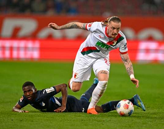 10.04.2026, Fussball 1. Bundesliga 2025 2026, 29.Spieltag, FC Augsburg - TSG 1899 Hoffenheim, in der WWK-Arena Augsburg. Bazoumana Toure (TSG 1899 Hoffenheim) am Boden, Marius Wolf (FC Augsburg) ***DFL and DFB regulations prohibit any use of photographs as image sequences and or quasi-video.*** *** 10 04 2026, Soccer 1 Bundesliga 2025 2026, Matchday 29, FC Augsburg TSG 1899 Hoffenheim, at WWK Arena Augsburg Bazoumana Toure TSG 1899 Hoffenheim on the ground, Marius Wolf FC Augsburg DFL and DFB regulations prohibit any use of photographs as image sequences and or quasi video