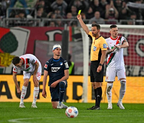 10.04.2026, Fussball 1. Bundesliga 2025 2026, 29.Spieltag, FC Augsburg - TSG 1899 Hoffenheim, in der WWK-Arena Augsburg. Albian Hajdari (TSG 1899 Hoffenheim) sieht die gelbe Karte von Daniel Schlager (Deutschland) ***DFL and DFB regulations prohibit any use of photographs as image sequences and or quasi-video.*** *** 10 04 2026, Soccer 1 Bundesliga 2025 2026, Matchday 29, FC Augsburg TSG 1899 Hoffenheim, at WWK Arena Augsburg Albian Hajdari TSG 1899 Hoffenheim sees yellow card from Daniel Schlager Germany DFL and DFB regulations prohibit any use of photographs as image sequences and or quasi video