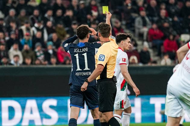 Fussball: Deutschland: 1. Bundesliga 2025 2026 - 29. Spieltag, 10.04.2026 - FC Augsburg vs. TSG Hoffenheim - WWK Arena (Augsburg, Deutschland); Schiedsrichter Daniel Schlager zeigt Fisnik Asllani (TSG Hoffenheim) die gelbe Karte *** Soccer Germany 1 Bundesliga 2025 2026 Matchday 29, 10 04 2026 FC Augsburg vs TSG Hoffenheim WWK Arena Augsburg, Germany Referee Daniel Schlager shows Fisnik Asllani TSG Hoffenheim the yellow card Copyright: xLUKAxKOLANOVICx